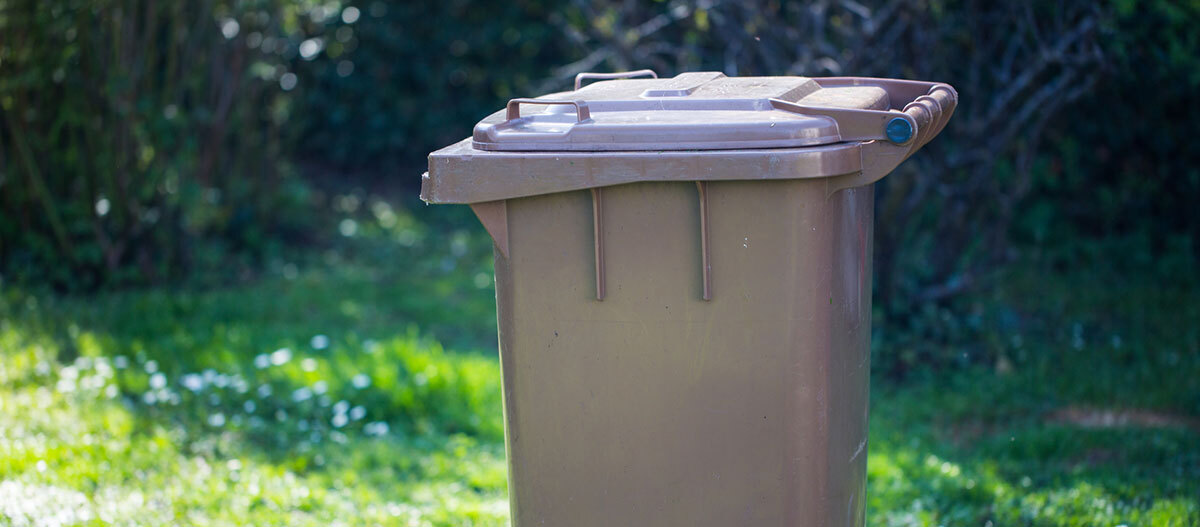 Ratgeber-Katze-Gesundheit-Katzenstreu_Tonne_1200x527 Eine braune Mülltonne.