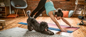 Eine Frau macht Yoga mit ihrem Hund