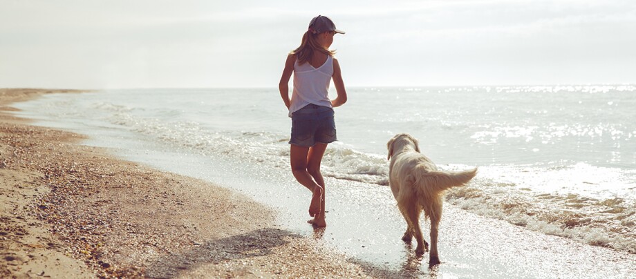 Mädchen läuft mit Hund am Strand Mädchen läuft mit Hund am Strand