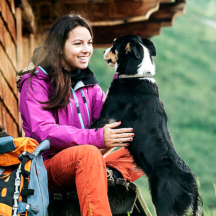 Frau mit Hund vor Hütte bei Wanderung Frau mit Hund vor Hütte bei Wanderung