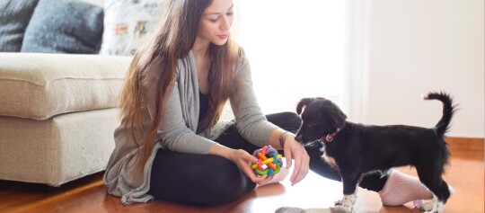 Eine Frau spielt mit einem Welpen
