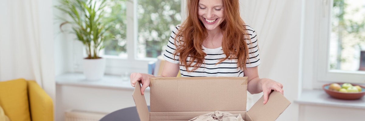 Frau öffnet Paket mit Fressnapf Bestellung