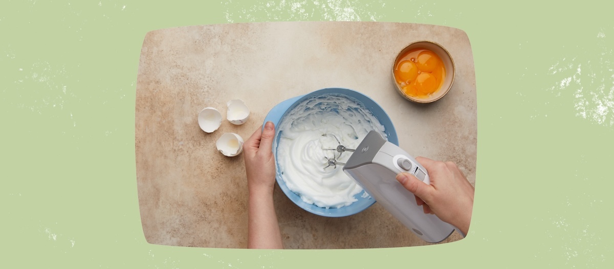 3 leere Eierschalen, Rührschüssel, Hände die Mixer halten, Eigelb in Schale 3 leere Eierschalen, Rührschüssel, Hände die Mixer halten, Eigelb in Schale